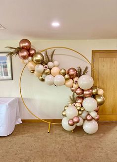 the balloon arch is decorated with gold, white and pink balloons