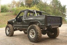 a black jeep with four wheels parked on the side of a road