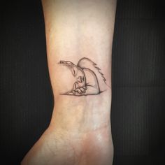 a small tattoo on the wrist of a woman's hand with a bird flying over it