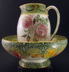 two vases sitting on top of each other with flowers painted on the bottom and sides