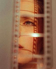 a woman's face is seen through a film strip