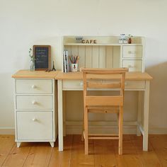 a desk with two chairs and a chalkboard on the wall