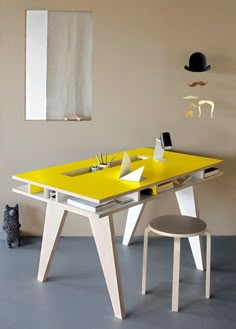 a yellow table and chair in a room with a pink wall on the other side