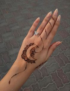 a woman's hand with henna tattoos on it and a diamond in the middle