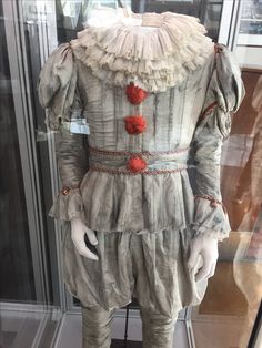 an old fashioned clown costume on display in a glass case