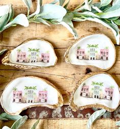 four oyster shells with pink houses painted on them