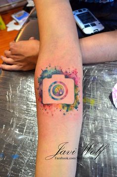 a person with a camera tattoo on their arm