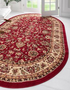 a large red rug in a room with white walls and flooring on the side