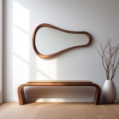 a wooden bench sitting next to a white vase on top of a hard wood floor