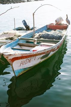 two small boats sitting in the water next to each other