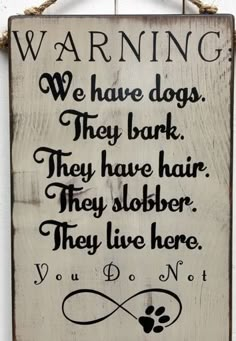 a wooden sign that says warning we have dogs they bark they have hair they slobber they live here