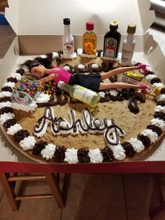 a birthday cake that is on top of a table with liquor and condiments