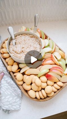 a bowl of oatmeal and apples on a tray