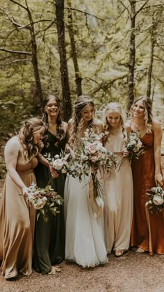 a group of women standing next to each other holding bouquets in their hands and smiling at the camera