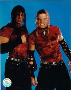 two men dressed in red and black posing for the camera