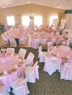 a room filled with lots of tables covered in pink and white cloths, decorated with minnie mouse centerpieces