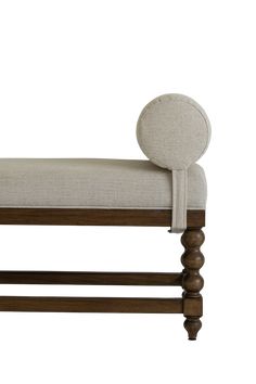 an upholstered bench with wooden legs and a buttoned cushion on the back