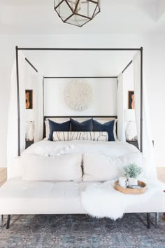 a bed with white sheets and pillows in a bedroom next to a rug on the floor