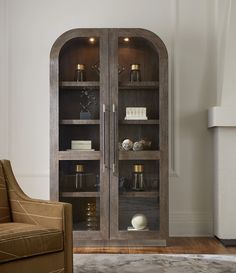 a wooden bookcase with glass doors in a living room