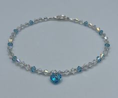 "This stunning anklet is designed using fine European quality 4mm clear AB crystals, 4mm aquamarine crystals and an 8mm beautiful sparkling \"something blue\" crystal heart dangle. This anklet is finished with a sterling silver plated lobster clasp and soldered jump ring for added security. These crystals have a gorgeous sparkle!  A sprinkling of aquamarine crystals add to this stunning piece.   A perfect \"something blue\" anklet for your special day - or any day! If you don't see your size ple Adjustable Blue Anklets For Party, Elegant Blue Anklets For Gifts, Adjustable Blue Crystal Bracelet, Blue Beach Anklets, Ocean-inspired Blue Beaded Anklet, Blue Anklet, Wedding Anklets, Heart Anklet, Crystal Anklet