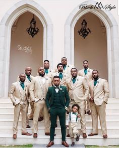 a group of men standing next to each other in front of a building with chandeliers