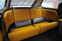 the interior of a car with yellow and black seats