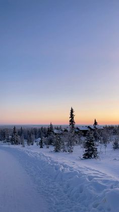 the sun is setting over a snowy landscape