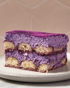 two pieces of cake sitting on top of a white plate next to a pink tiled wall