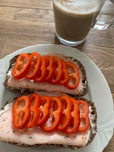 two open faced sandwiches with tomato slices on them next to a cup of coffee and a glass of milk