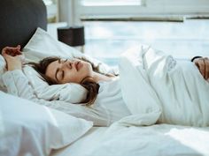 a woman laying in bed with her eyes closed