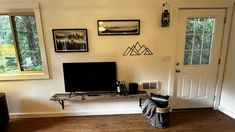 a flat screen tv sitting on top of a wooden table in a living room next to a door