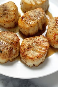 seared scallops on a white plate with sauce