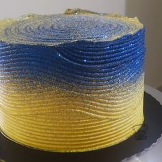 a yellow and blue cake sitting on top of a white plate