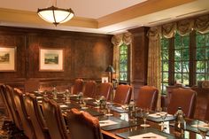 a large conference room set up with long tables and chairs for people to sit at