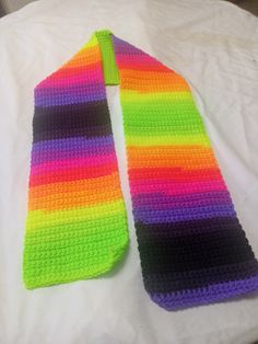 a colorful knitted tie laying on top of a bed