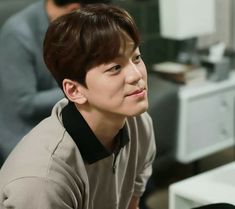 a young man sitting in front of a computer monitor