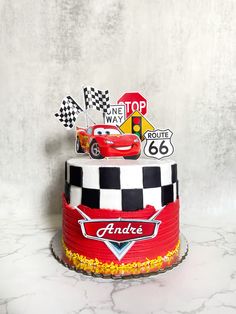 a red and white cake with cars on top