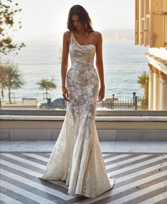 a woman in a white dress is standing on the street