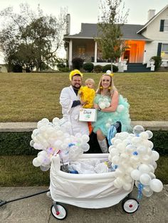 a man and woman dressed up in costumes posing for a photo with a baby in a stroller