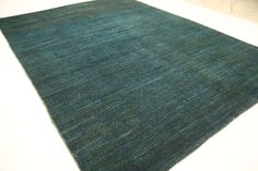 a blue area rug on top of a white floor