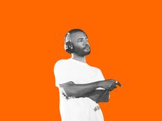 a man with headphones standing in front of an orange background