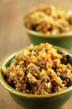 two green bowls filled with food on top of a wooden table