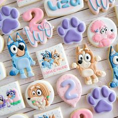 cookies decorated with cartoon characters and letters on a wooden surface, one cookie has the number two