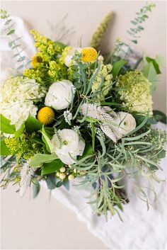 a bouquet of white and green flowers on a table