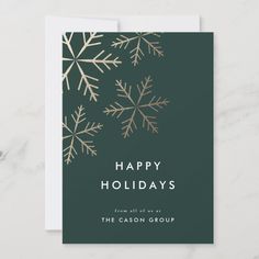 a holiday card with gold foil snowflakes on green and white background, reads happy holidays from all of us at the cason group