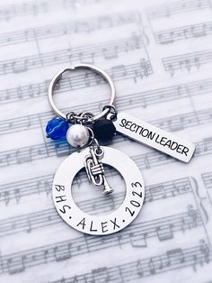 a keychain with a name tag attached to it on top of sheet music