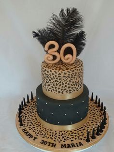 a birthday cake decorated with leopard print, feathers and the number thirty six on top