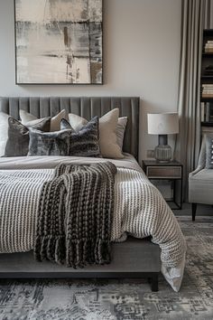 a bedroom with a large bed, chair and painting on the wall above it's headboard