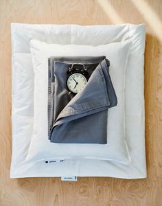 an alarm clock in a pocket on a pillow