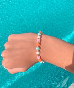 a person wearing a bracelet with beads on their wrist